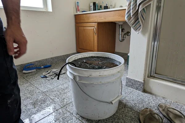 Bucket of dark rinse water collected after a chemical wash