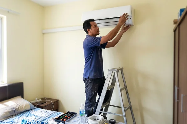 Technician reassembling the cleaned indoor unit