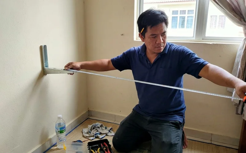 Technician measuring the piping run along a wall