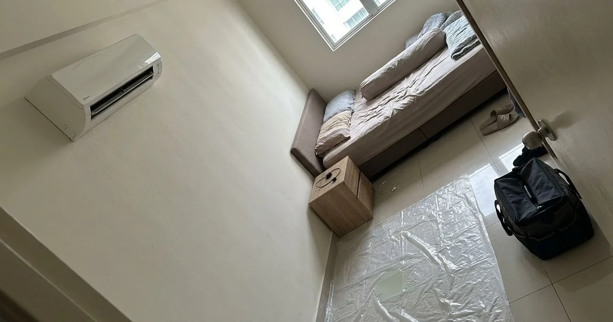 Bedroom with furniture moved aside and a plastic sheet under the aircon