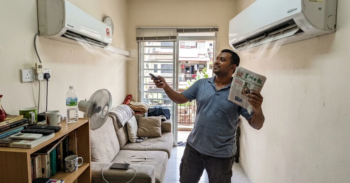 Man holding the remote under a wall aircon on a hot afternoon